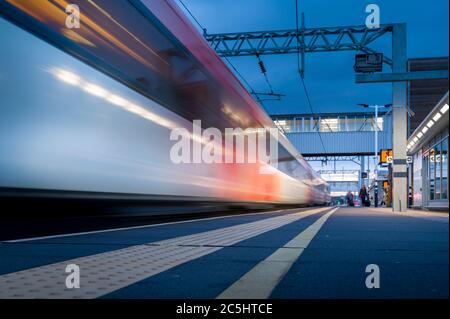 LNER high speed train sppeding through a railway station on the east ...