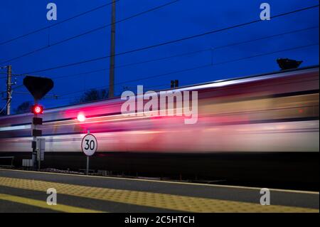 LNER high speed train sppeding through a railway station on the east coast main line, England, UK.