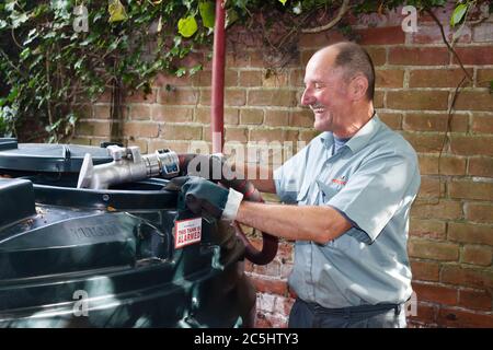 BUCKINGHAM, UK - September 13, 2014. Man filling a bunded oil tank with domestic heating oil (kerosene) at a home in rural England, UK Stock Photo