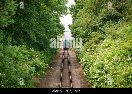 Fast approaching vintage steam locomotive with its coal tender seen head first. Stock Photo