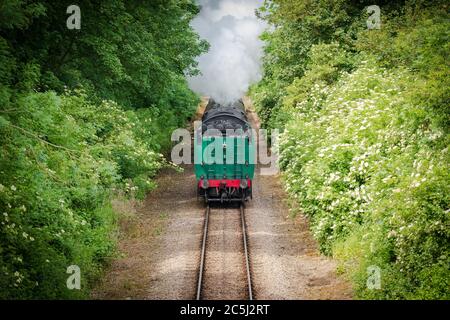 Fast approaching vintage steam locomotive with its coal tender seen head first. Stock Photo