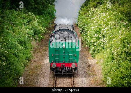 Fast approaching vintage steam locomotive with its coal tender seen head first. Stock Photo