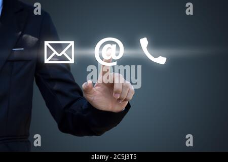Hand pressing telephone, email button icon over blue background. Customer support concept Stock Photo