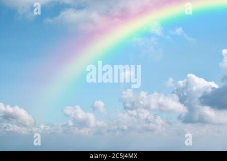 Rainbow on blue sky with white cloud background. Stock Photo