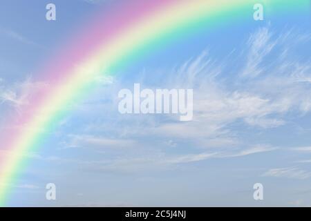 Rainbow on blue sky with white cloud background. Stock Photo