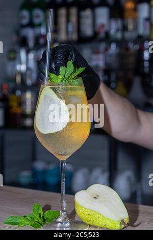 Refreshing summer cocktails with a slice of lime. Alcoholic drink. Garnished with a sprig of mint, citrus and ice cubes. In the bar. Foreground. Stock Photo