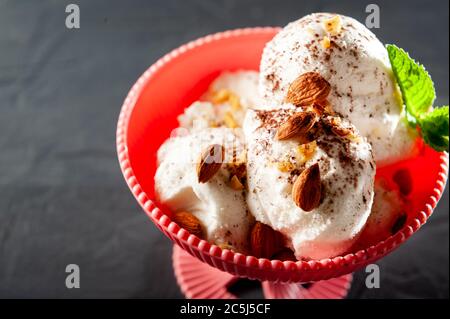 balls of ice cream white filling on a black background with mint and chocolate and cocoa. Summer eats and top view Stock Photo