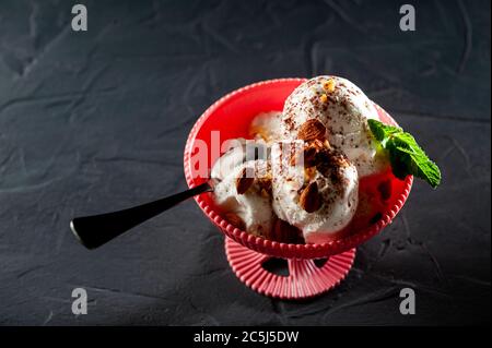 spoon with ice cream on a black background, ice cream summer mood cool. Ice cream white promsemin with mint and chocolate Stock Photo