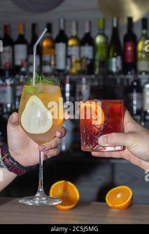 Refreshing summer strong cocktails with a slice of lime. Alcoholic drink. Garnished with a sprig of mint, citrus and ice cubes. In the bar. Foreground Stock Photo
