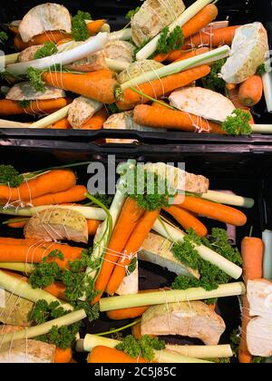 Close up of isolated bundles of fresh raw soup vegetables on german farmer market: leeks, carrots, celery and parsley Stock Photo