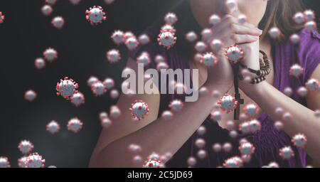 Covid-19 cells against woman with rosary praying Stock Photo