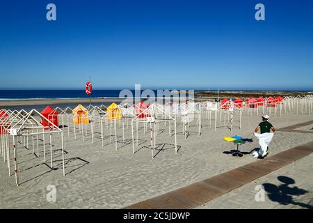 3rd July 2020, Vila Praia de Ancora, northern Portugal: A local government worker puts out bin bags on the beach in preparation for the start of the tourist season. Stock Photo