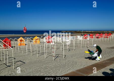 3rd July 2020, Vila Praia de Ancora, northern Portugal: A local government worker puts out bin bags on the beach in preparation for the start of the tourist season. Stock Photo