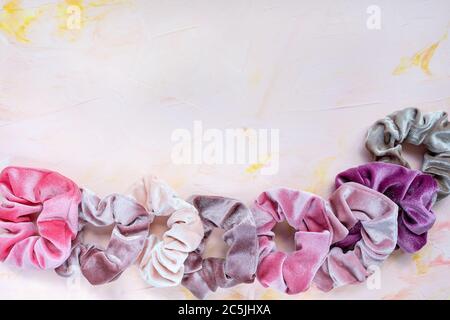 Collection of trendy velvet scrunchies on pink background Stock Photo