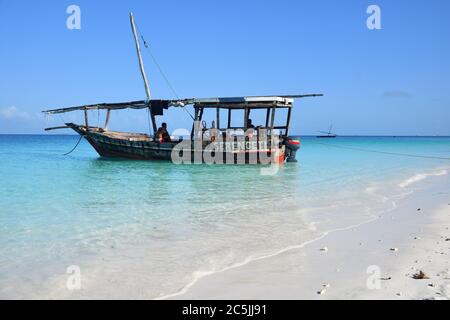 Kendwa, Tanzania - October 6, 2019: Dhow boat with locals men moored on the Kendwa beach, Zanzibar, Africa Stock Photo