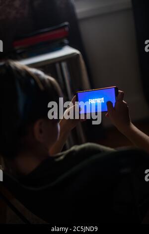 Bucarest, Romania - June 25. 20202: Image a child playing Fortnite, a game by Epic Games, on a mobile phone in Bucharest, Romania. Stock Photo