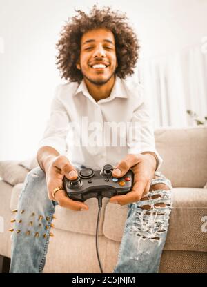 Free Photo  Gamer using controller to play online video games on computer.  man playing game with joystick and headphones in front of monitor. player  having gaming equipment, doing fun activity.