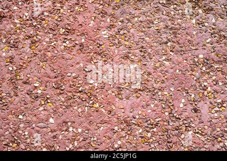 Texture wall coating of stones. House wall exterior plaster. Abstract background paving consisting of small pebbles embedded in cement Stock Photo