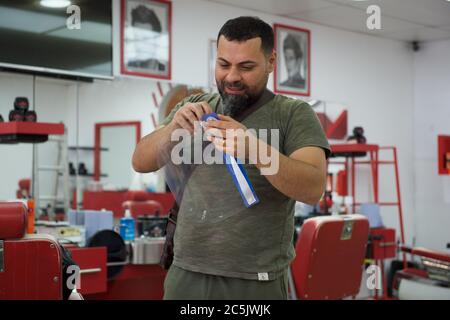 Sidcup, Kent, UK. 03rd July, 2020. A partner in Red Barber Shop in Sidcup High Street tries a face shield as they prepare to reopen after covid 19 lockdown rules are relaxed by the government. Sidcup, Kent on 3 July 2020. Photo by Alan Stanford. Credit: PRiME Media Images/Alamy Live News Stock Photo