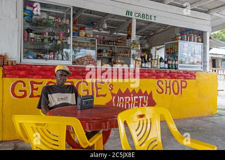 Shopkeeper in front of little grocery shop, Essequibo Islands-West Demerara Region, Guyana, South America Stock Photo