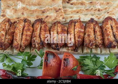 Turkish cuisine chicken wings grill. Heap fried on a grill of chicken wings with sauce and spice cocktails. Stock Photo