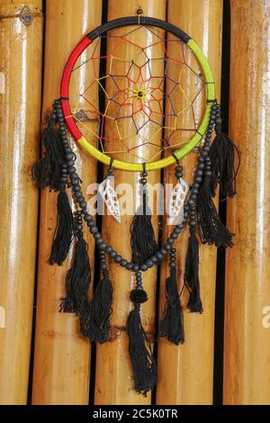 Beautiful multicolored handmade dreamcatcher with sea shells on natural bamboo background. Stock Photo