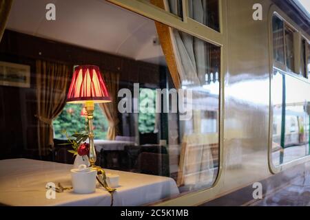 Shallow focus of an ornate, period dining table lamp seen in a First Class dining area. Stock Photo