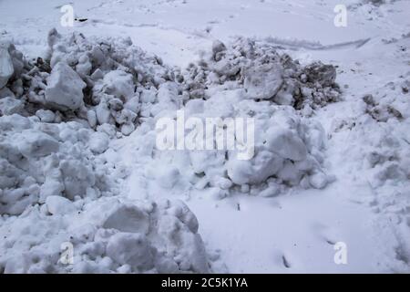 A winter background with Piles of dirty snow.  Texture of dirty snow. Winter stock photo of piles of snow. Stock Photo