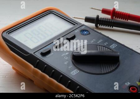 Close-up of a multimeter on a light background. Detailed shot of a measuring device. Qualified electrician services. Selective focus. Stock Photo