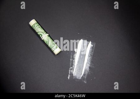 The Dangerous Cocaine with one dollar. Heroine on black background. Stock Photo