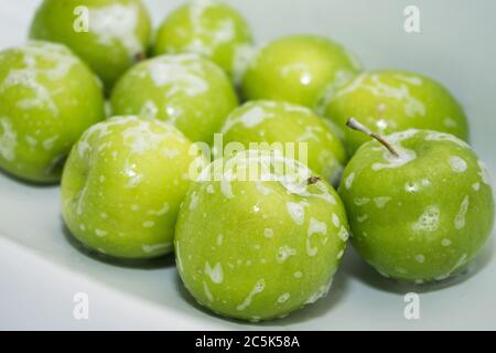Washing fruit. Soapy green apples in the sink.  Stock Photo