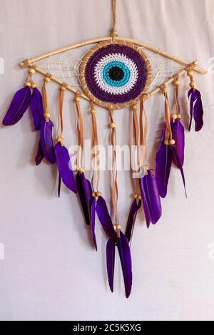 divine eye of providence dreamcatcher with colored feathers on a white background. Stock Photo
