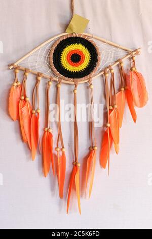 divine eye of providence dreamcatcher with colored feathers on a white background. Stock Photo