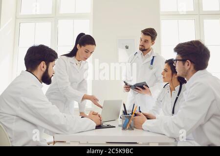 Group of doctors on meeting at hospital. Team of medical specialists discussing patient treatment at clinic Stock Photo