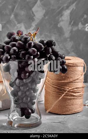 Bunches of fresh ripe dark grapes on a concrete textural surface. Red wine grapes. Still life of food. Nature. Autumn harvest. Vegetarian nutrition Stock Photo