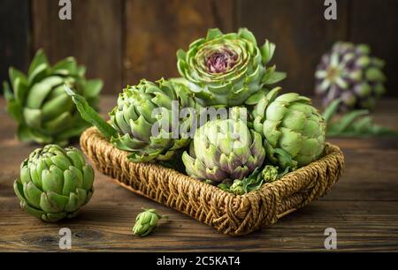 Fresh and raw artichoke on the wooden table Stock Photo