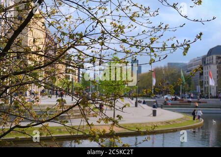 A spring day at Kö-Bogen in downtown Düsseldorf, seen through the branches of a tree with blurred background. Stock Photo
