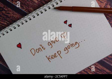 Don't Give up Keep Going write on a book isolated wooden table. Stock Photo