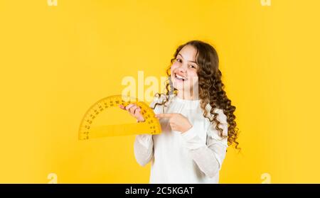 Excited about knowledge. mathematics and people concept. geometric shapes. modern education concept. girl with protractor and triangle ruler. back to school. STEM school disciplines. copy space. Stock Photo