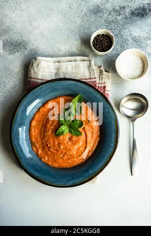 Traditional spanish tomato soup Gazpacho served in ceramic bowl with fresh basil leaves on stone background with copy space Stock Photo
