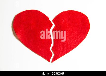 Broken red heart made of felt. Broken love concept.  A broken heart isolated on a white background. A  pain in my heart Stock Photo
