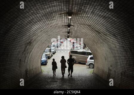 Pedestrians pass through the Žižkov Tunnel (Žižkovský tunel) near the north portal of the tunnel in Thámova Street in Karlín district in Prague, Czech Republic. The pedestrian tunnel under Vítkov Hill joining Žižkov and Karlín districts was built between 1951 and 1953. Stock Photo