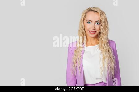Attractive beautiful business European woman smiling with delight girl with long hair studio shot isolated on gray background, feeling of happiness gently looking at the camera Stock Photo