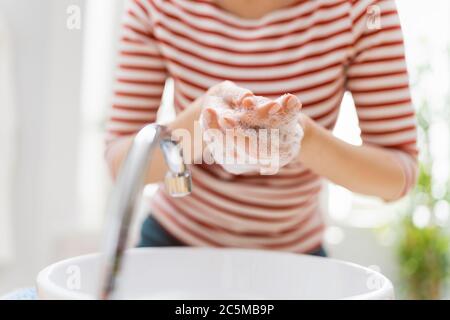 Person is washing hands rubbing with soap. Protection against coronavirus. Prevention, hygiene to stop spreading virus. Stock Photo