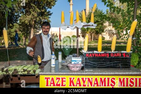 A man working at his corn cob stall at Ayn-i Zeliha, the second sacred pool in Golbasi Park in Sanliurfa in eastern Turkey. Stock Photo