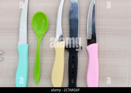 Colorful knives close display on a white texture surface. Cutter and chopper knife display under bright light. Stock Photo