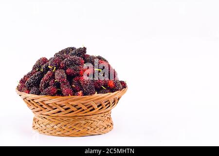 fresh organic mulberries in brown basket on white background healthy mulberry fruit food isolated Stock Photo