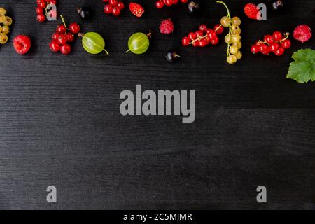 Wooden background with berries with copy space. Flat lay composition with frame border made of mixed berries. Raspberries, cherries, gooseberries, str Stock Photo