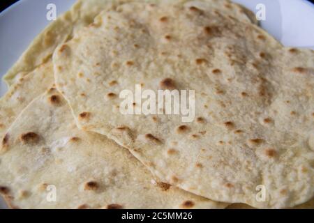 Delicious pita bread made at home in a pan. Thin pita bread on a white plate Stock Photo