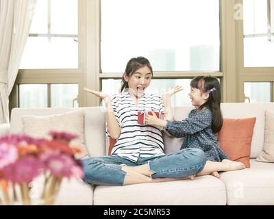 young asian woman receiving a gift from daughter on mother's day Stock Photo